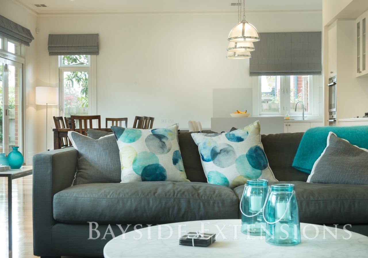 grey couch with turquoise throw pillows